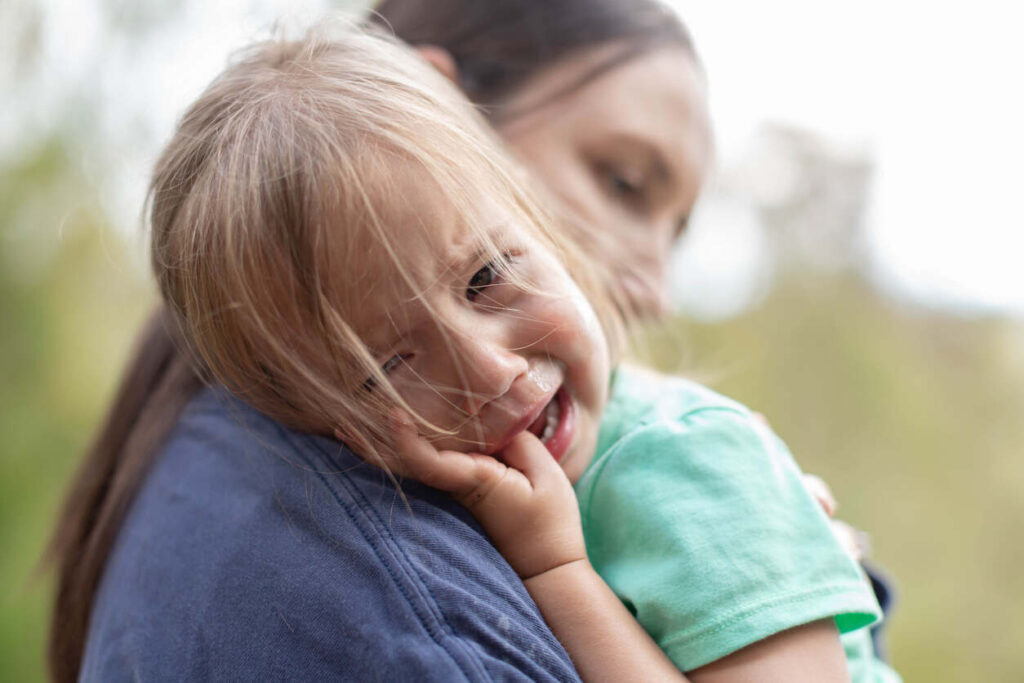 Upset child being held, highlighting the emotional aspect of daycare injuries and potential indicators of neglect or abuse.